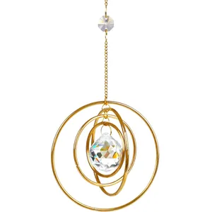 Golden suncatcher with nested metal rings and a multifaceted crystal ball for window decor
