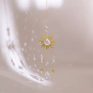 Detail of golden suncatcher with faceted crystal ball creating rainbow light reflections