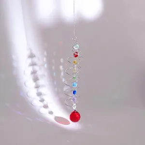 Macro detail of suncatcher with spiral metal wire and multifaceted red crystal ball