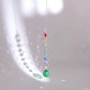 Close-up of spiral suncatcher with rainbow crystals and green faceted glass ball