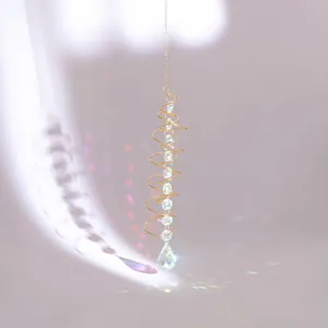 Detail of golden heart spiral stabilizer with crystal teardrop making rainbow light