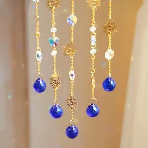 Detail of five-piece suncatcher set with golden evil eye metal charms and blue crystal drops