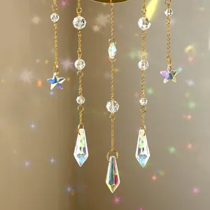 Macro view of gold suncatcher featuring multi-faceted K9 crystal stars and teardrop prisms