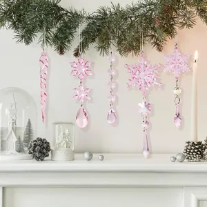 Detail of pink acrylic icicle and snowflake ornaments hanging on a Christmas tree