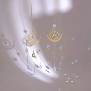 Large sun and moon crystal suncatcher with golden charms reflecting rainbow light