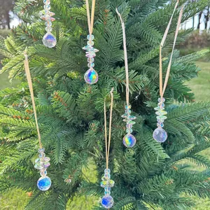 Detail of multi-faceted crystal suncatchers hanging on pine branches with gold cords
