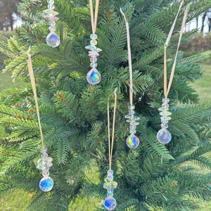Detail of 6-piece iridescent crystal suncatchers hanging on green pine branches