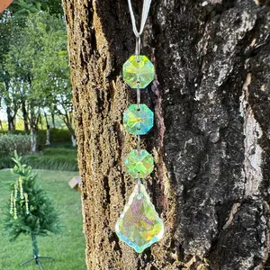 Detail of green and AB crystal suncatcher hanging on a tree with light refraction