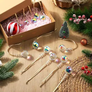 Close-up of faceted crystal teardrop pendants with golden strings in a gift box