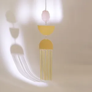 Modern pink crystal wind chime with golden copper tubes and geometric metal hanging plates