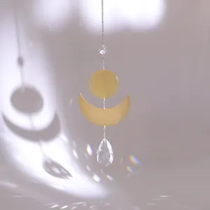 Macro detail of suncatcher showing golden crescent moon and crystal prism rainbow light
