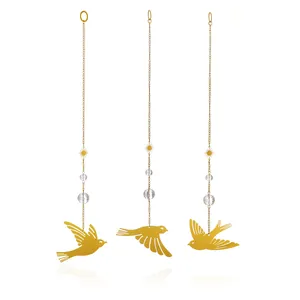 Detailansicht von drei goldenen Metallvogel-Anhängern mit hängenden Kristallen und Sonnen
