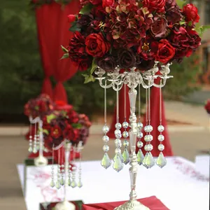Silver multi-arm candelabra centerpieces with red roses and hanging crystal glass prisms