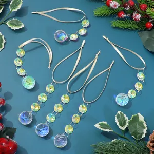 Detail of five crystal suncatchers with faceted beads on a festive pine needle background