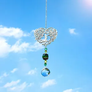 Detail van levensboom hart zonnevanger met groene kralen en kristallen bol tegen blauwe lucht