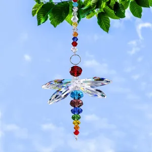 Detailed dragonfly suncatcher with colorful crystals hanging from a tree branch