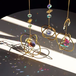 3-piece suncatcher set with sun and moon prisms casting rainbows on a white wall