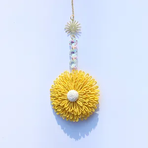 Handmade raffia flower pendant with iridescent beads and golden sun charm for garden decor
