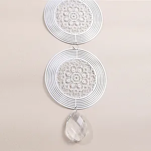 Detail view of 3D rotating wind spinner with mandala pattern and crystal teardrop pendant