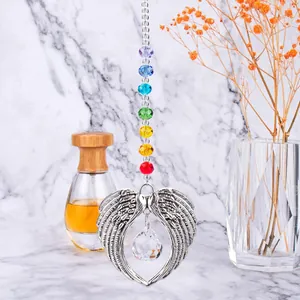 Detail of angel wing suncatcher with chakra beads and crystal ball on marble background