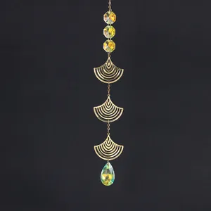 Close-up of crystal suncatcher with golden ginkgo leaves and iridescent prisms