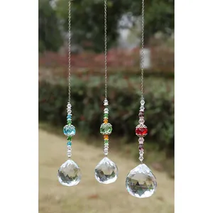 Three crystal suncatchers with faceted spheres and colorful beads hanging in a garden