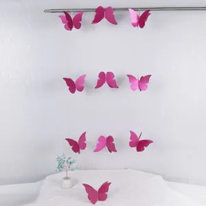 Detalle de guirnalda de mariposas 3D rosa con purpurina colgada en barra metálica