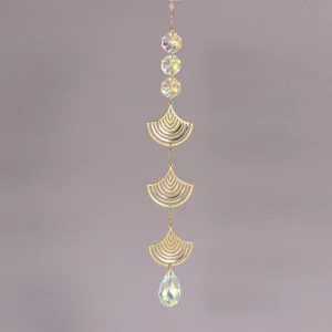 Macro detail of golden ginkgo leaf suncatcher with teardrop crystal and prism beads