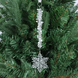 Gros plan d'un pendentif flocon de neige en acrylique avec perles sur un sapin de Noël