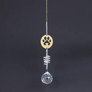 Detail of crystal sun catcher featuring a gold paw print pendant and large faceted prism ball