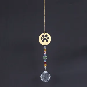 Macro view of crystal suncatcher featuring golden paw print and rainbow prism glass beads