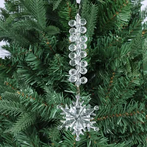 Gros plan d'un flocon de neige en acrylique transparent avec perles sur un sapin de Noël