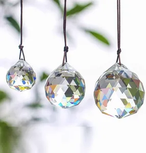 Close-up of faceted crystal suncatcher balls hanging with multi-color light refraction