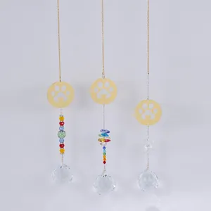 Three gold paw print crystal suncatchers with rainbow beads and multifaceted prism spheres
