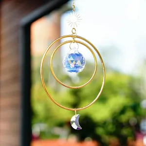 Detail of sun and moon crystal suncatcher featuring golden metal rings and faceted prisms