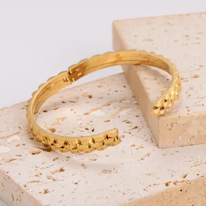 18K gold gear-shaped hinged bangle with wave-edged polished metal on stone