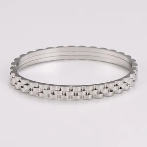 Macro shot of silver gear-shaped bangle with scalloped edges and polished metallic finish