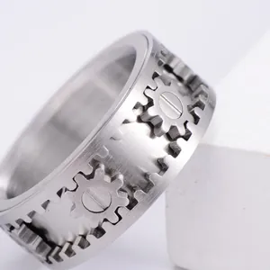 Mechanischer Edelstahl-Spinner-Ring mit drehbaren Zahnradkomponenten auf weißem Block