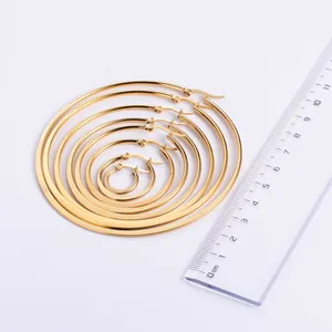 Detail view of gold hoop earring set in multiple sizes with measurement scale ruler