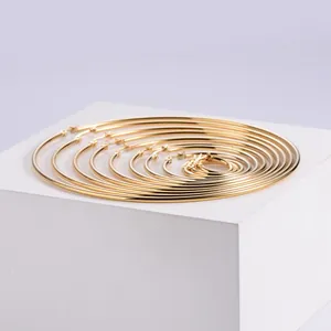 Detailed set of multi-size gold hoop earrings arranged neatly on a white display stand