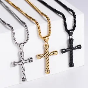 Detailansicht der Kreuzanhänger in Gold, Silber und Schwarz auf einem weißen Ständer