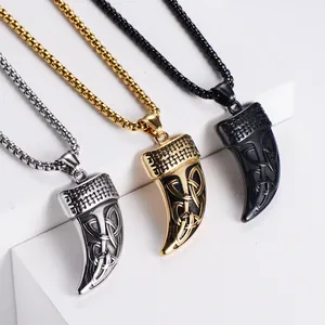 Detailed view of three wolf tooth pendants with Celtic knot patterns in silver gold and black