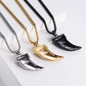 Detailed view of tusk-shaped pendants in silver, gold, and black with Celtic knot patterns