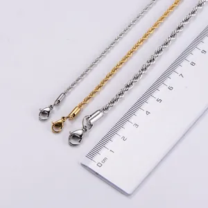 Close-up of gold and silver rope chains with lobster clasps and measuring ruler