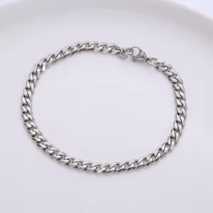 Polished silver stainless steel Cuban link bracelet with lobster clasp on a white plate