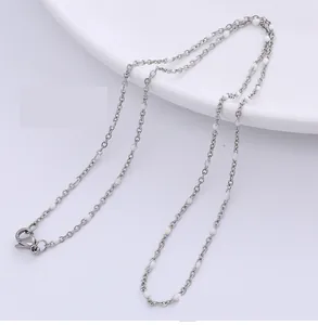 Minimalistische silberne Edelstahlhalskette mit kleinen weißen Emailleperlen für Damen