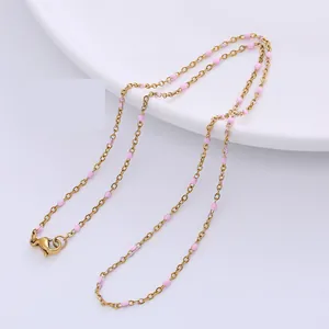 Nahaufnahme der goldenen Edelstahlkette mit zarten rosa Emaille-Perlen und Karabinerverschluss