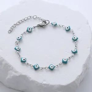Detailed macro view of square blue evil eye charms on a silver stainless steel chain