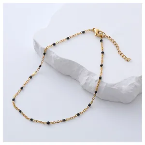 Bohemian gold stainless steel anklet with black beads on a white marble stand