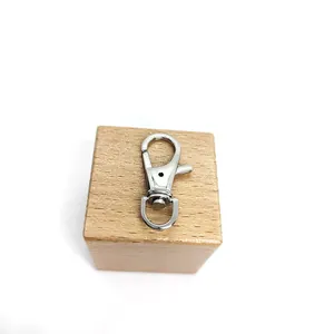 Gepolijste zilveren roestvrijstalen karabijnsluiting op een minimalistisch houten blok